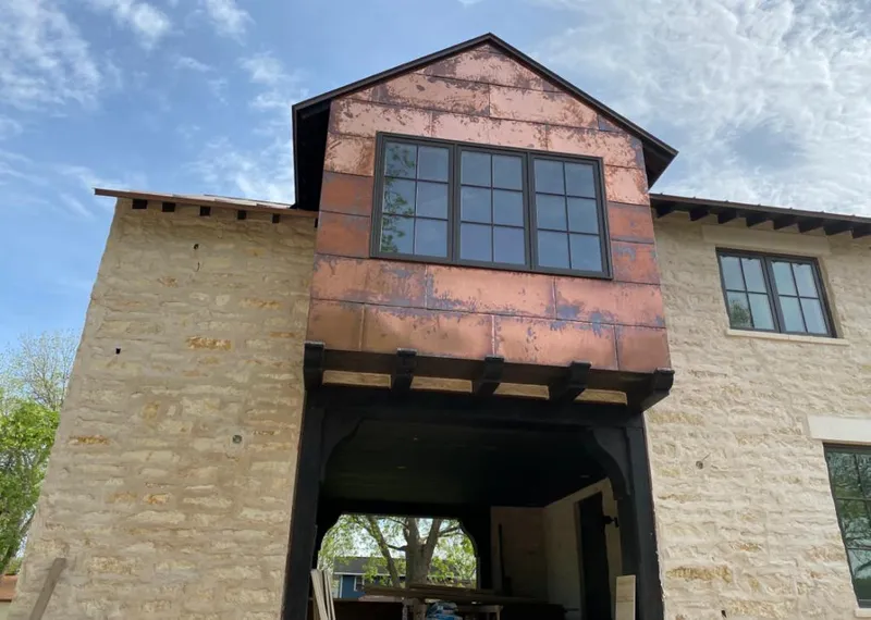 Copper metal panel facade on a stone building for Roof Repair in Spring Creek